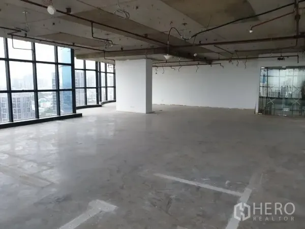 办公空间 出租在Watthana, Bangkok - 宽敞毛坯办公层，外露天花与玻璃幕墙，城市景观。