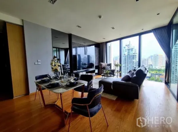 Condominium for rent in Khlong Toei, Bangkok - Open-plan lounge and dining area with hardwood floors and panoramic city outlook.