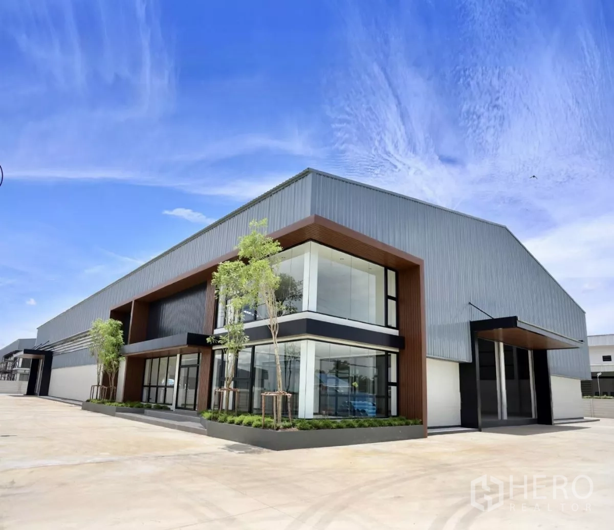 Factory for rent or sale in Phutthamonthon, Nakhon Pathom - Modern factory exterior with a two-storey glass-front office and wide concrete yard in Phutthamonthon.