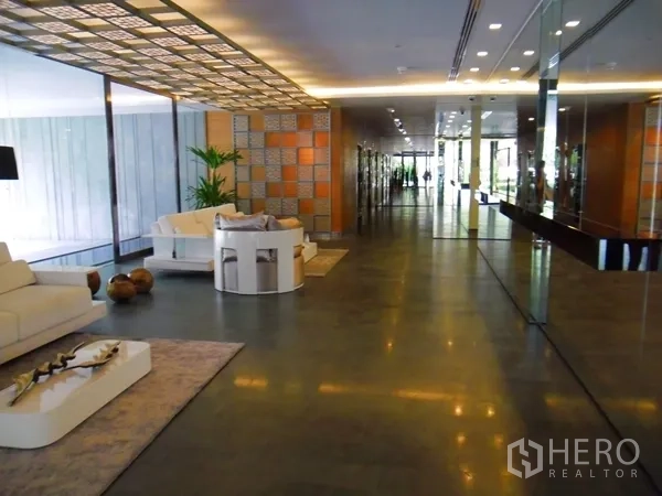 公寓 出租或出售在Watthana, Bangkok - 时尚公寓大堂，设休闲沙发与镜面墙。
