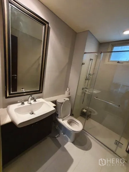 公寓 出租在Khlong San, Bangkok - 宽敞客厅，深色木地板，落地门通阳台，沙发与书桌。