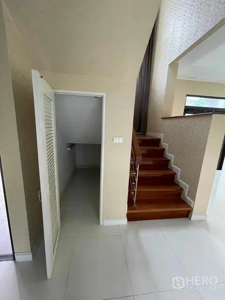 独立式住宅 出售在Lat Krabang, Bangkok - 客厅内楼梯旁的楼梯下储物柜。