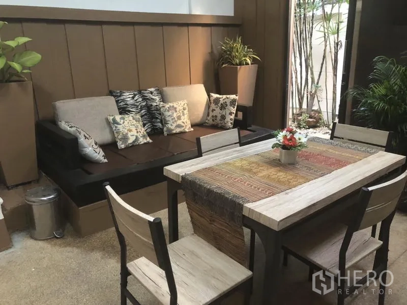 Townhouse for rent in Bang Kapi, Bangkok - Cozy courtyard lounge with table, bench seating and greenery for alfresco living.