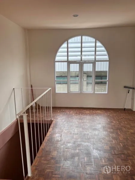 Shophouse for rent or sale in Watthana, Bangkok - Upper level landing with parquet floor and arched window bringing in natural light.