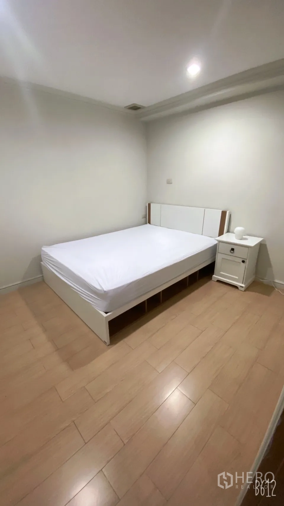 คอนโด ให้เช่าในWatthana, Bangkok - ห้องนอนที่สองพร้อมเตียงสีขาว โต๊ะหัวเตียง และพื้นไม้โทนอุ่น
