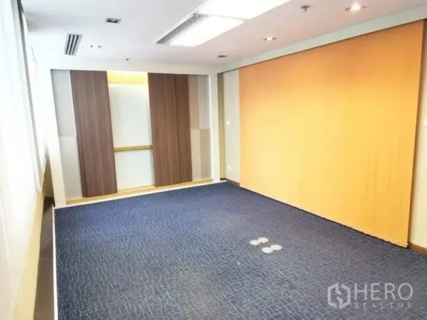 Office Space for rent - Bright meeting or training room with blue carpet, wood panel wall and recessed lighting.