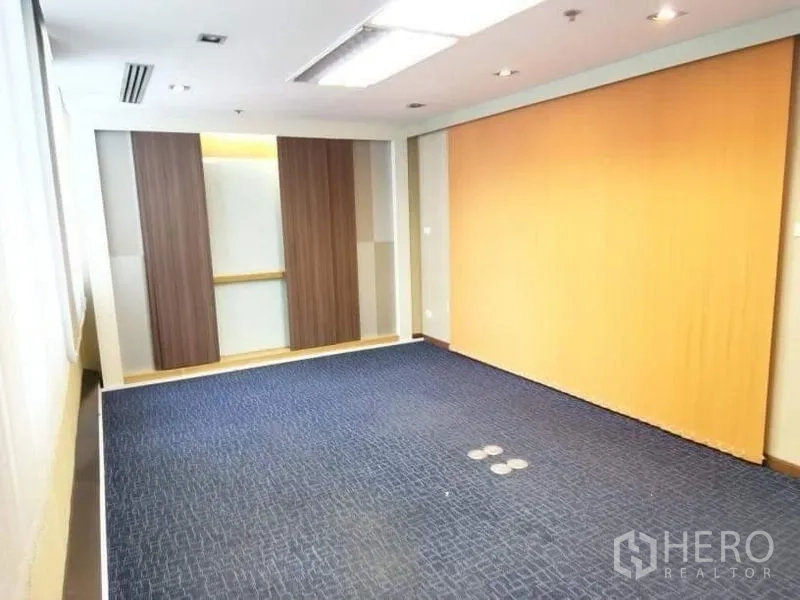 Office Space for rent - Bright meeting or training room with blue carpet, wood panel wall and recessed lighting.