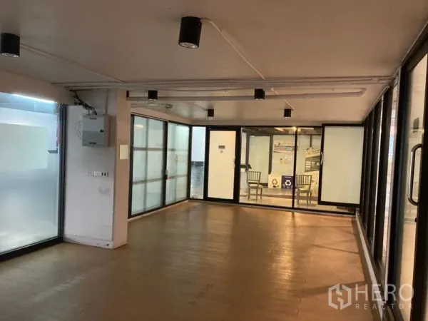 Retail Space for rent in Khlong Toei, Bangkok - Bright retail space with wraparound glazing, multiple glass doors, and an electrical panel.