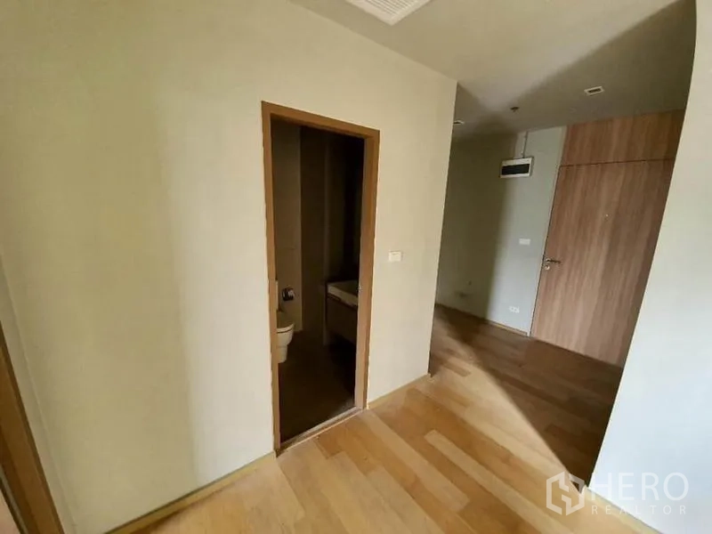 公寓 出售在Ratchathewi, Bangkok - 卧室入口在浴室旁，极简室内与木地板。