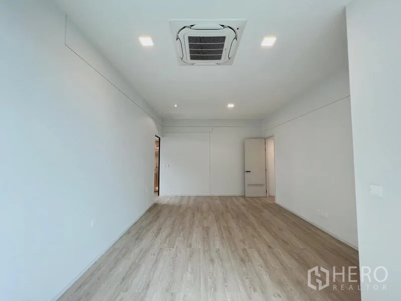Detached House for rent or sale in Saphan Sung, Bangkok - Wide bedroom with ceiling cassette air-conditioner and wood floors.