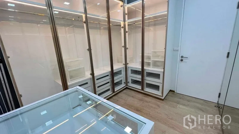 Condominium for rent in Watthana, Bangkok - Luxury dressing room with illuminated glass wardrobes and drawers.