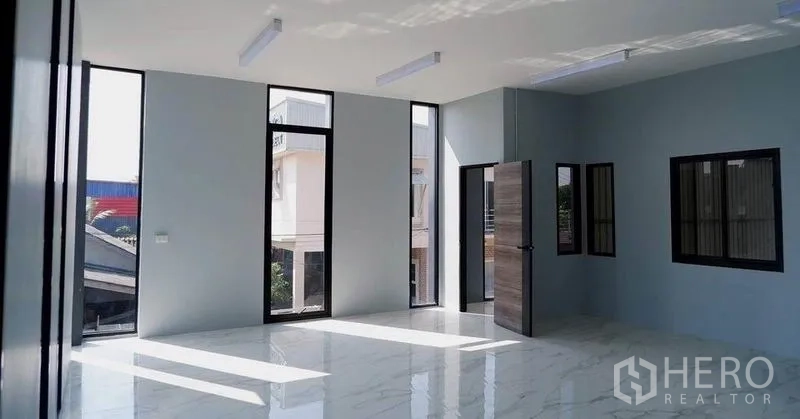 Warehouse for rent in Bueng Kum, Bangkok - Upper-level office area featuring tall windows and glossy tile flooring.