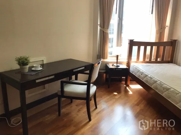 公寓 出租或出售在Pathum Wan, Bangkok - 舒适次卧，单人床、书桌与椅子，落地窗采光充足。
