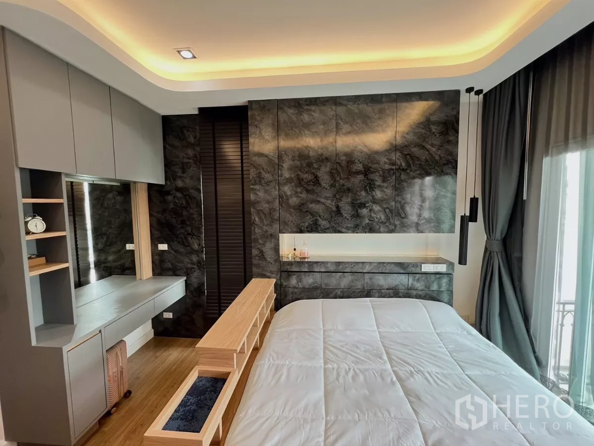 Detached House for rent or sale in Khlong Luang, Pathum Thani - Master bedroom with marble accent wall, dressing table and platform bed.