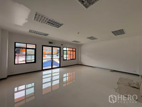 工厂 出租在Bang Pakong, Chachoengsao - 一层办公室采光明亮，瓷砖地面，玻璃门与黑框窗。