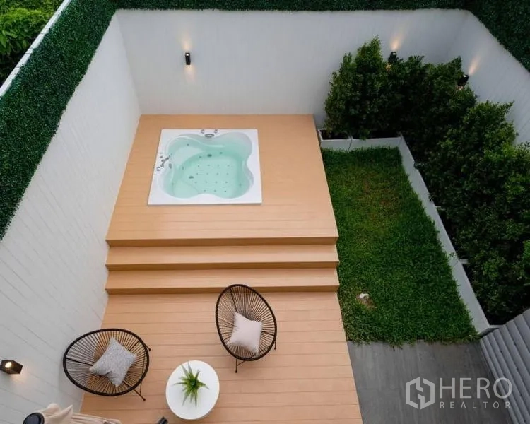 Townhouse for sale in Khlong Toei, Bangkok - Private courtyard with elevated jacuzzi on a wooden deck, seating area and small lawn.