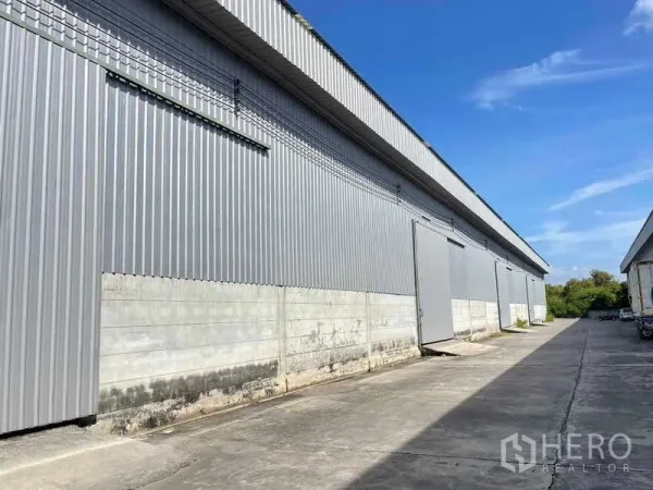 工厂 出租在Bang Pakong, Chachoengsao - 金属板外墙的厂房外观，滑动门与宽阔卡车通道。