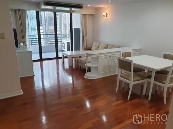 公寓 出租在Watthana, Bangkok - 开放式客餐厅，木地板，沙发组与通往阳台的大型落地门，可观城市景色