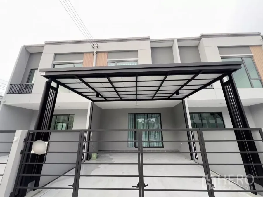 Townhouse for rent in Bang Phli, Samut Prakan - Modern two-storey townhouse exterior in Bang Phli with gated entrance and covered double carport.