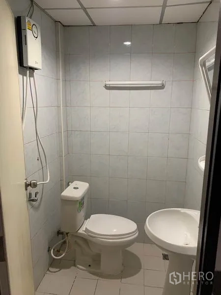 Retail Space for rent in Khlong Toei, Bangkok - Compact bathroom with toilet, pedestal sink and shower water heater.