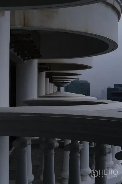 Condominium for rent in Bang Rak, Bangkok - Curved exterior balconies with classical balustrades on a high floor.