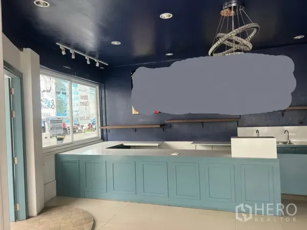 Retail Space for rent in Watthana, Bangkok - Service counter with blue cabinetry, sinks and shelving beneath spotlights and a modern chandelier.