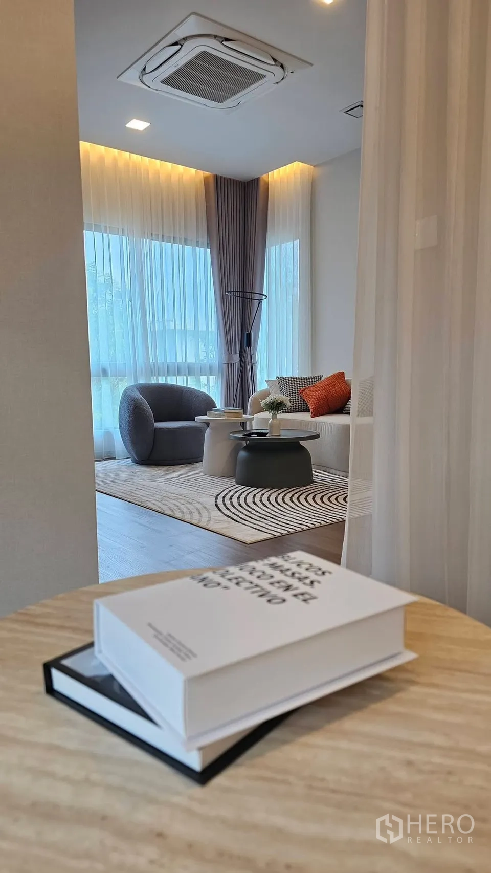 独栋房屋 for rent in Bang Phli, Samut Prakan - 客厅空间，通高纱帘、圆形座椅与沙发，从过道望去。