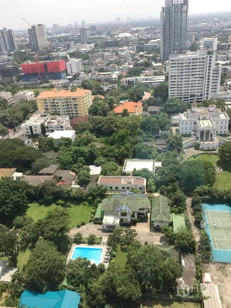 Condominium for rent or sale in Khlong Toei, Bangkok - High-floor city view over Khlong Toei with greenery, pool, tennis court and Bangkok skyline.