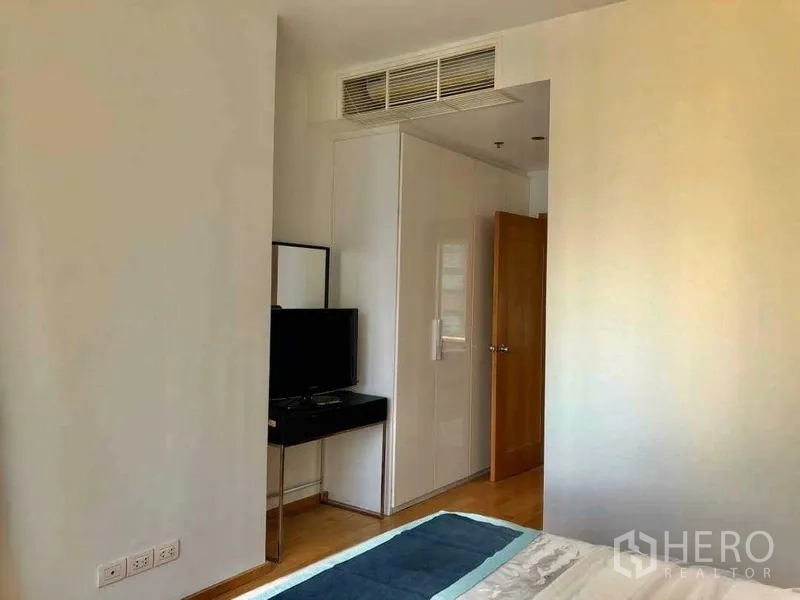 公寓 出售在Khlong Toei, Bangkok - 卧室一角，内置衣柜、壁挂电视与空调通风口