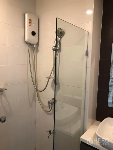 联排别墅 出租在Bang Kapi, Bangkok - 瓷砖浴室，玻璃淋浴间与电热水器。