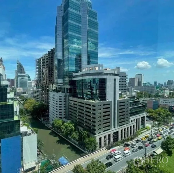 公寓 出租或出售 - 曼谷市中心高楼、运河与道路车流的城市景观。