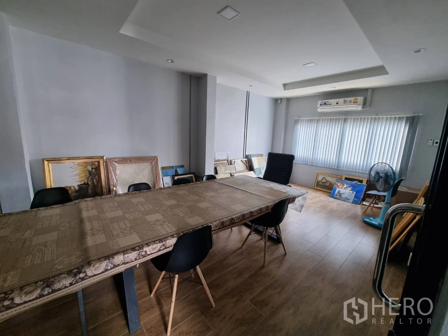 Home Office for rent in Phra Khanong, Bangkok - Meeting room with a long table, black chairs, air conditioner, and window blinds.