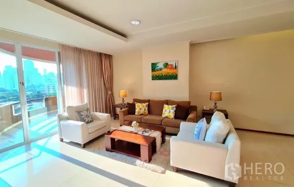คอนโด ให้เช่าในWatthana, Bangkok - มุมนั่งเล่นอบอุ่น โซฟาใกล้ผ้าม่านสูงจรดเพดานและประตูกระจกสู่ระเบียง