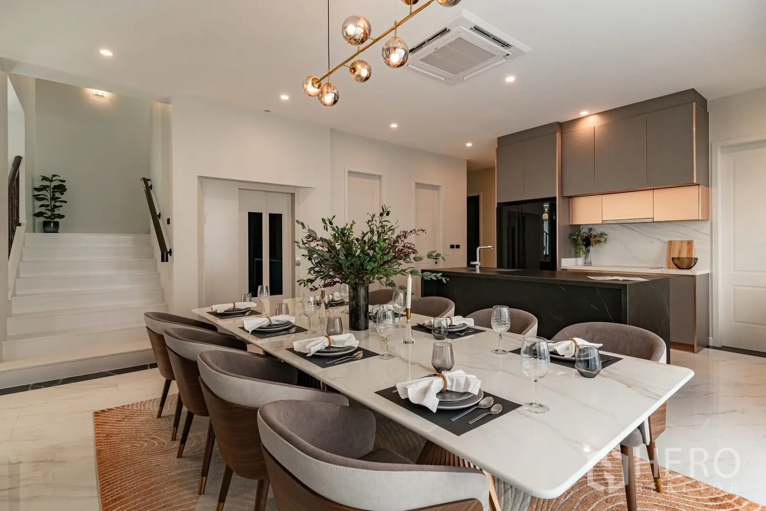 Detached House for rent or sale in Saphan Sung, Bangkok - Open dining area for eight beside a sleek kitchen and staircase.