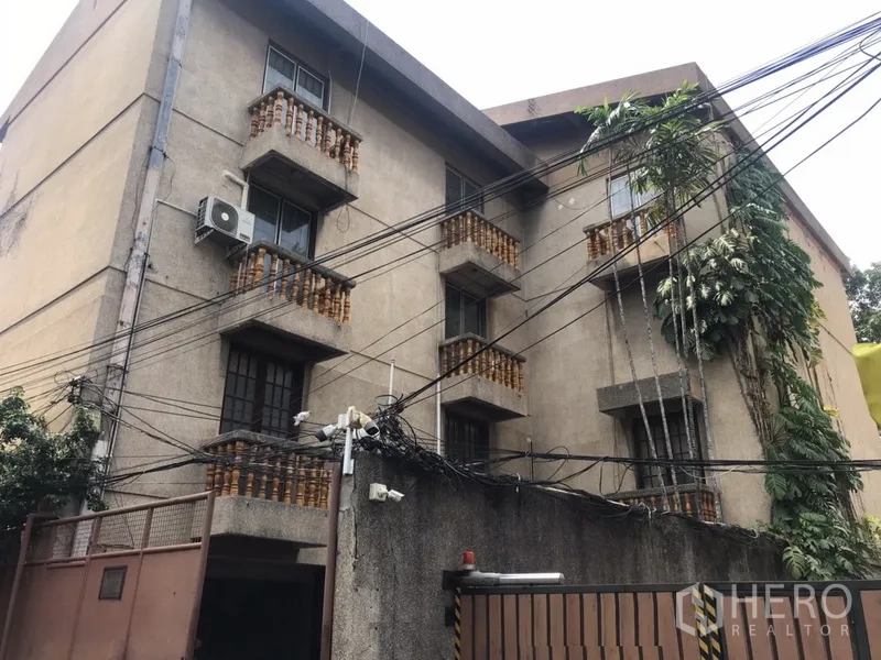 Home Office for rent in Khlong Toei, Bangkok - Multi-storey home office exterior with small balconies, gated entrance and overhead cables in the Sukhumvit area.