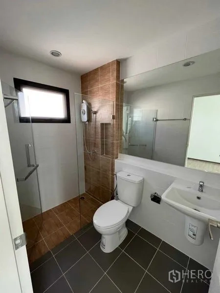 Detached House for rent or sale in Samut Prakan - Clean bathroom with glass shower, window, white vanity and toilet.