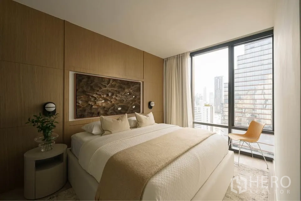 公寓 for rent in Bang Rak, Bangkok - 卧室配大床与木质装饰墙，落地窗可见天际线。