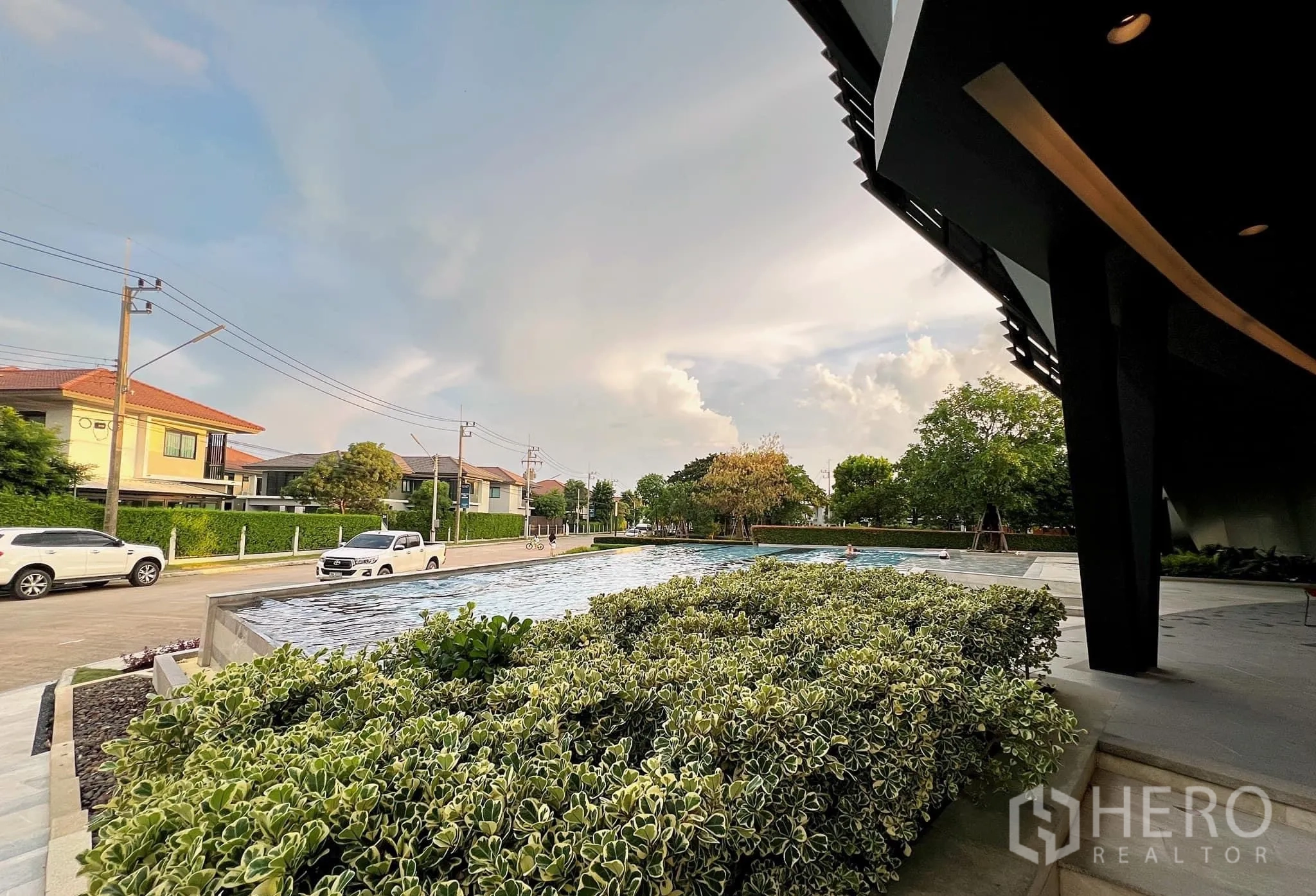 Detached House for rent or sale in Lam Luk Ka, Pathum Thani - Community clubhouse with reflective water feature and lush plantings.