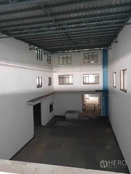 Warehouse for rent in Nong Khaem, Bangkok - High atrium space with corrugated metal roof and interior windows.