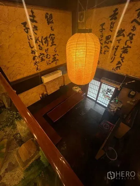 Shophouse for rent in Khlong Toei, Bangkok - Overhead view of the entrance hall with a large paper lantern and calligraphy walls.