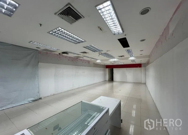 Retail Space for rent - Retail shop space with a glass display counter, white partition walls and recessed lighting in an open layout.