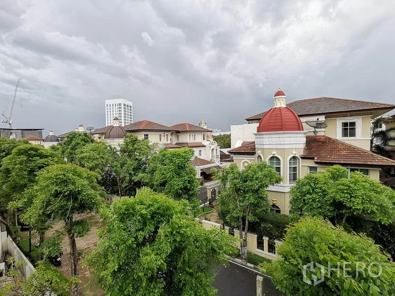 Townhouse for rent or sale in Yan Nawa, Bangkok - Tree-lined neighborhood view of low-rise residences with domed roofs.