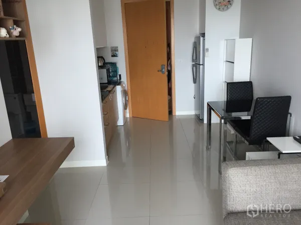 公寓 出租在Ratchathewi, Bangkok - 明亮客厅与开放式小厨房，配冰箱、洗衣机和玻璃餐桌，亮面地砖清爽。