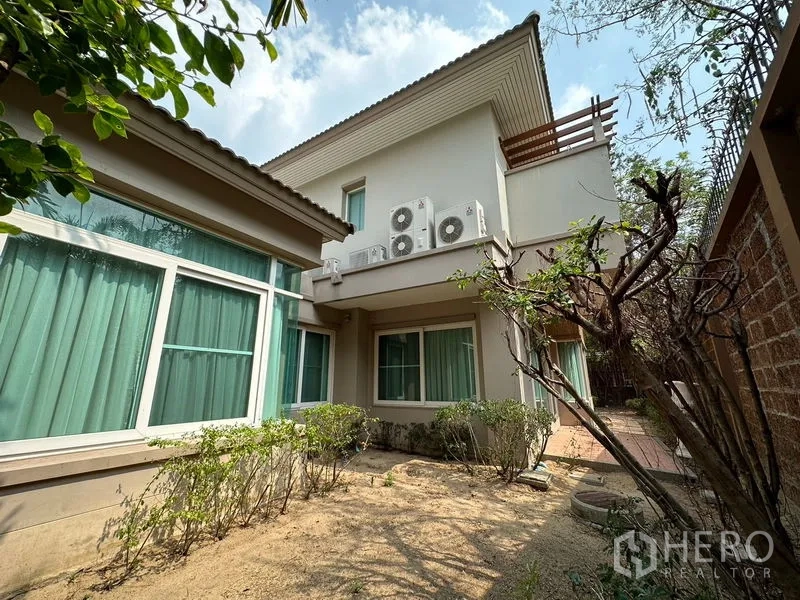 独立式住宅 出租或出售在Pak Kret, Nonthaburi - 房屋侧院与后立面，可见多组空调外机与窗户。