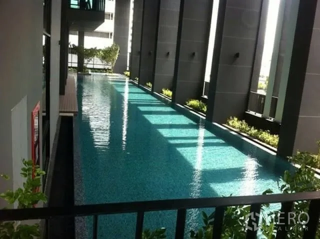 公寓 出租在Huai Khwang, Bangkok - 公寓设施泳池，长条景观池搭配绿植与遮阳。
