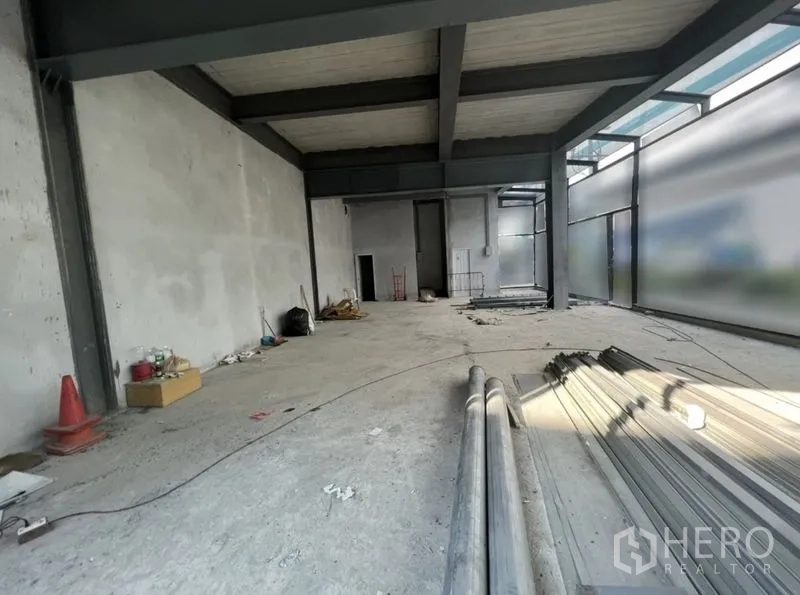 Retail Space for rent in Watthana, Bangkok - Open-plan retail interior with high ceiling, steel beams and frosted glass windows in shell condition.