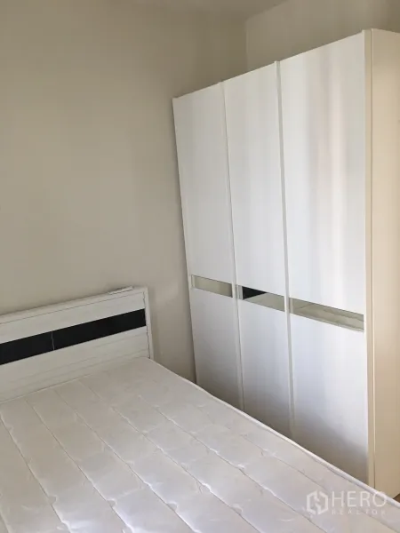 Condominium for rent in Phaya Thai, Bangkok - Second bedroom with white bed frame and sliding door wardrobe in neutral tones.
