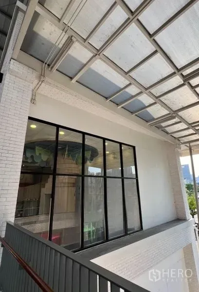 Retail Space for rent - Upper-floor space with large window wall under a canopy roof allowing natural light.