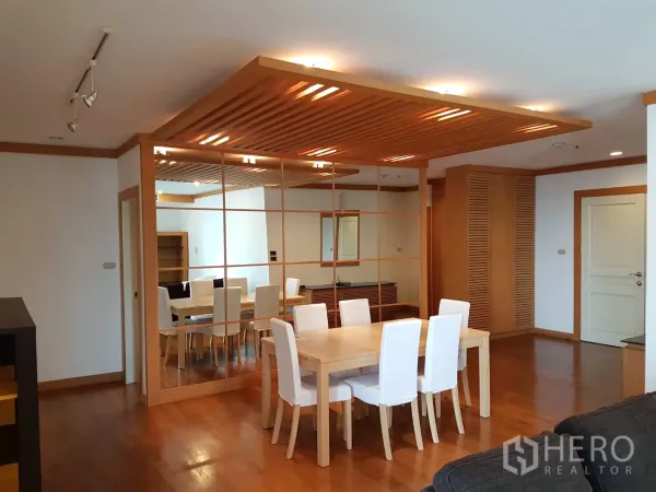 公寓 出租在Pathum Wan, Bangkok - 开放式客餐厅，木质装饰、轨道灯与镜面特色墙，空间感通透。