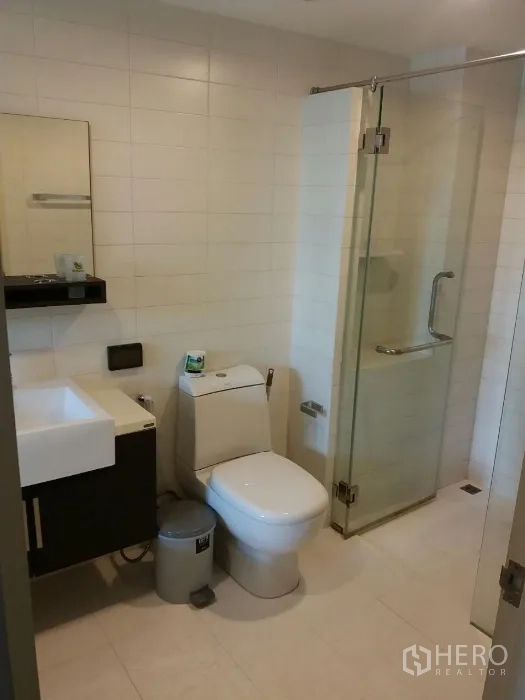 公寓 出租在Phaya Thai, Bangkok - 浴室内设玻璃淋浴间、坐便与壁挂式洗手台。